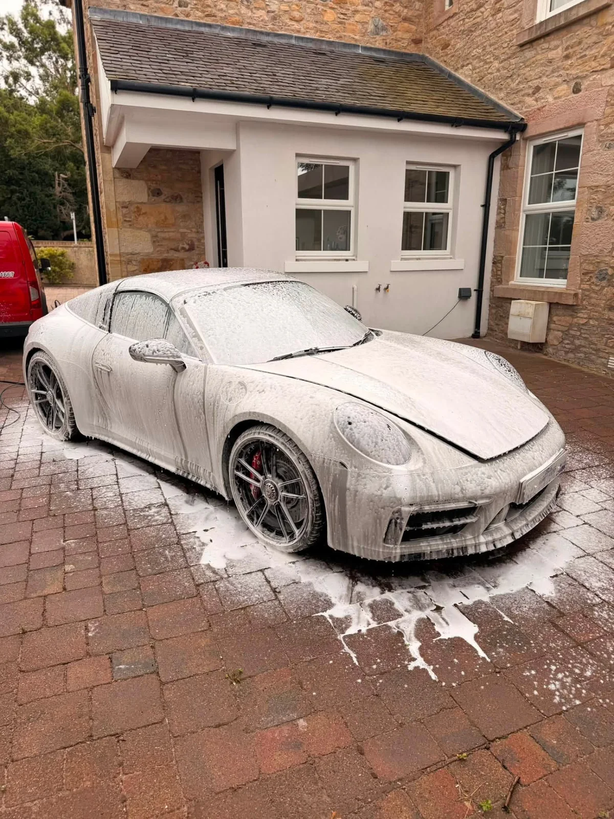 Porsche covered in cleaning foam during a deep clean